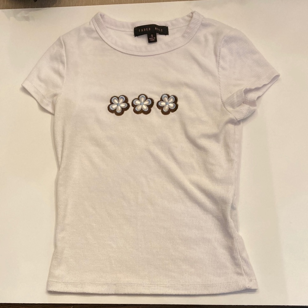 A white small crop top printed with flowers 67% polyester 29% rayon 4% spandex